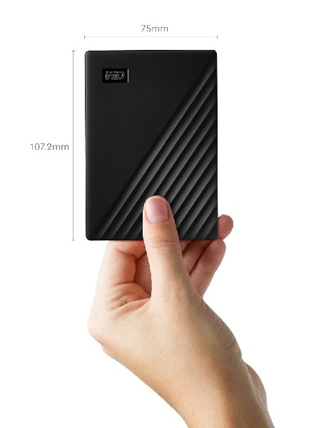Mano sosteniendo un disco duro externo negro con texto y detalles de dimensión.