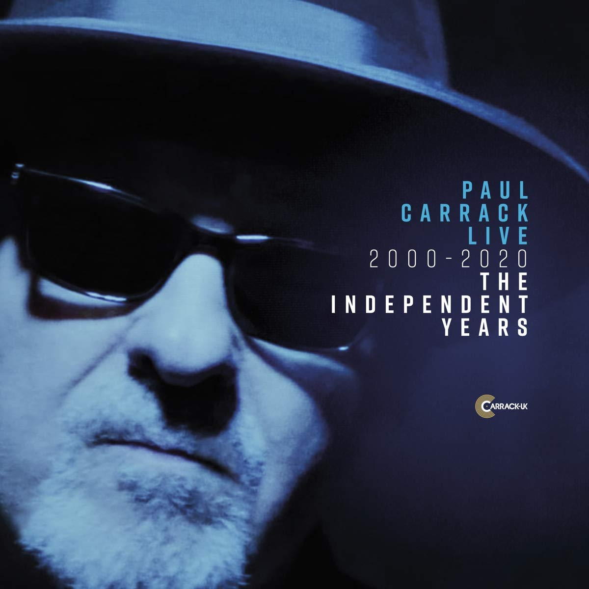 Paul Carrack Live album borító. Egy napszemüveges férfi közeli képe, kék és sötét tónusok.