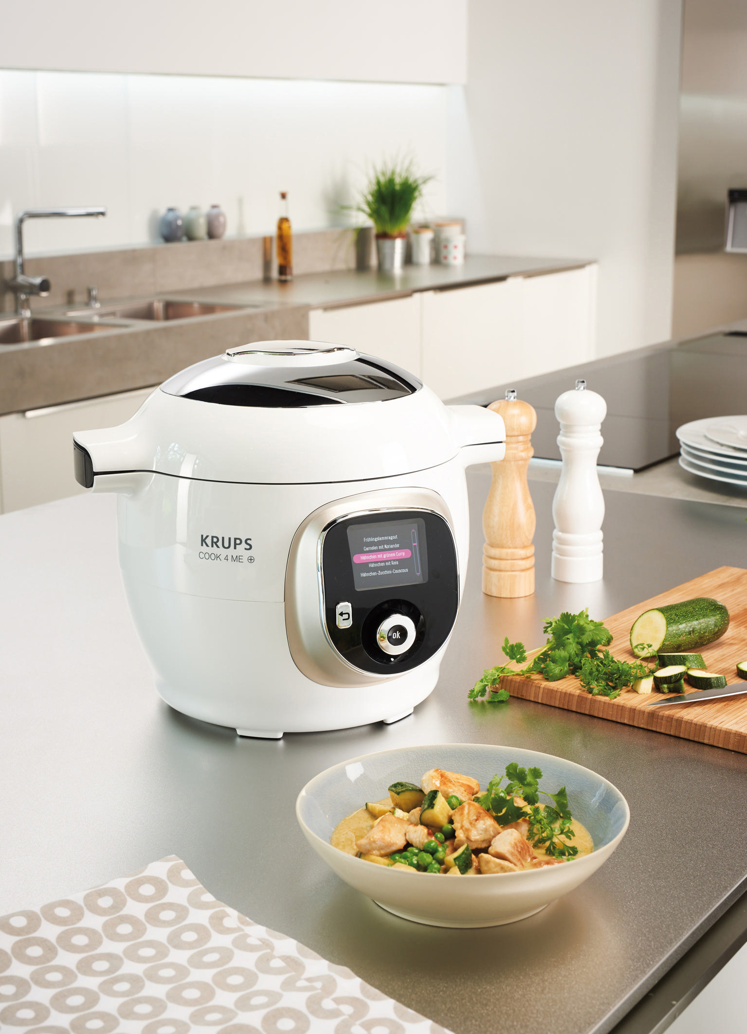Weißer und silberner Krups Cook4me+ auf einer Küchentheke neben Essen und Gewürzen.