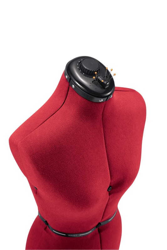 Eine rote Schneiderpuppe mit schwarzem, verstellbarem Hals und schwarzem Gürtel. Stecknadeln am Kopf.