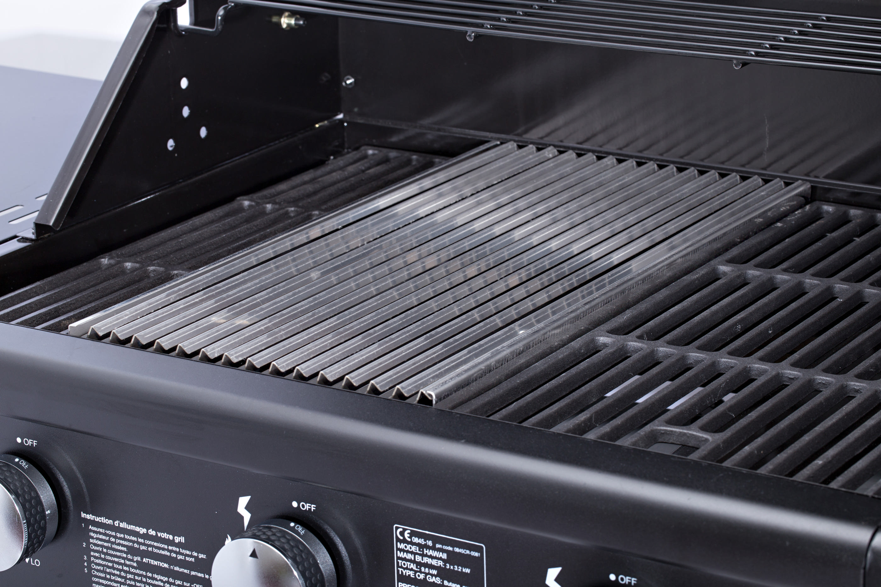 Nahaufnahme eines schwarzen Grills mit Metallrosten, mit Drehknöpfen und Tasten.