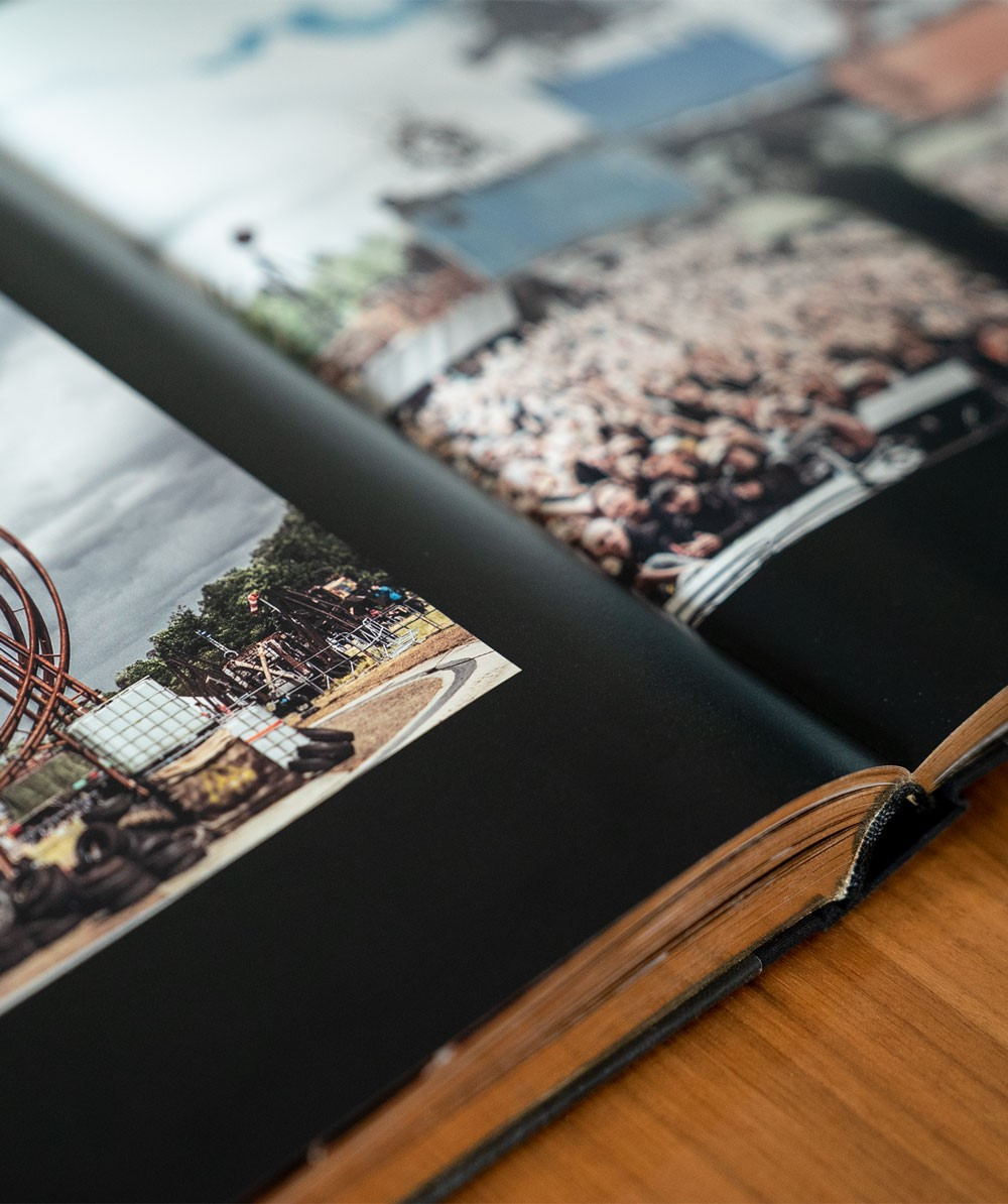 Offenes Buch mit Bildern, das Stadien eines Rennsports auf einem Holztisch zeigt.
