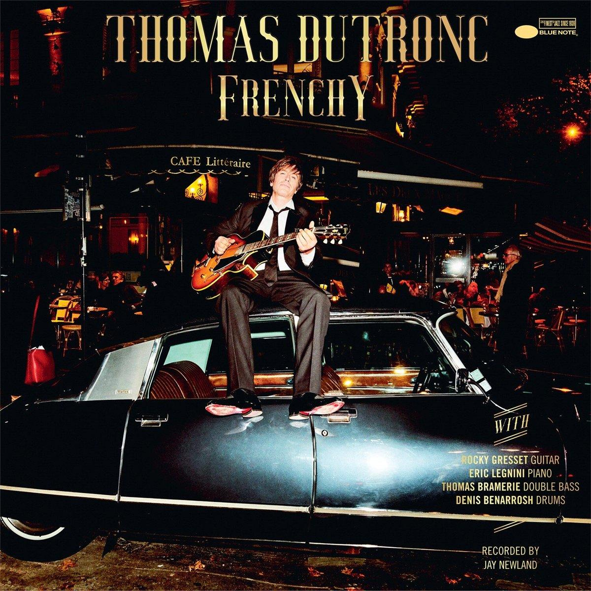 Man in pak zit op een auto. De band is Thomas Dutronc. Het album is Frenchy.