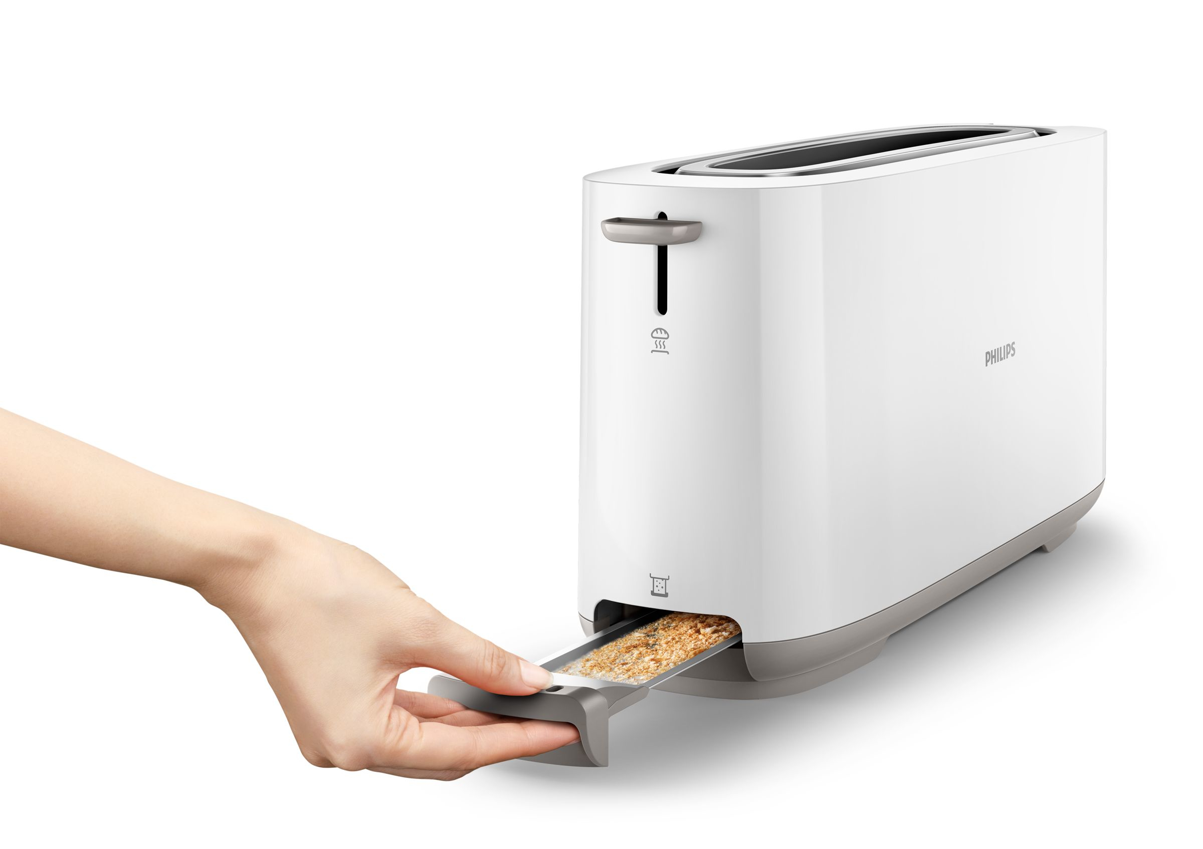 A white toaster with bread crumbs in the tray, a hand is pulling the tray.