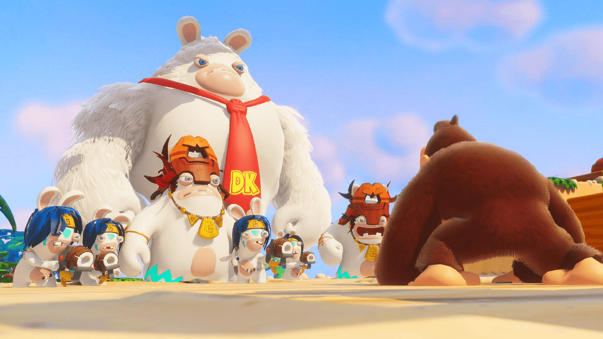 Donkey Kong steht Rabbids-Charakteren gegenüber an einem Strand, blauer Himmel im Hintergrund.