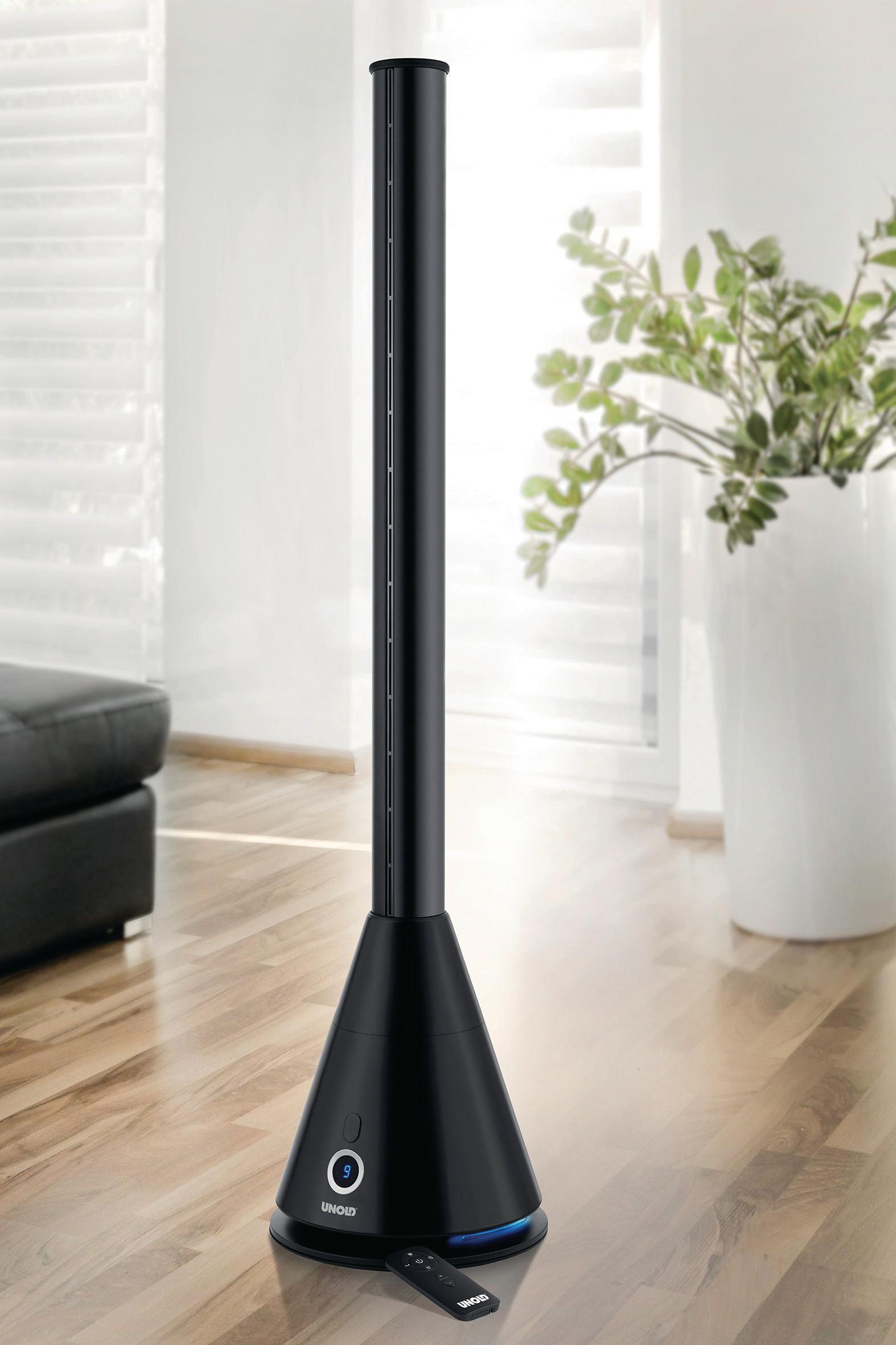 Schwarzer Turmventilator mit kegelförmigem Sockel. Eine Pflanze steht im Hintergrund.