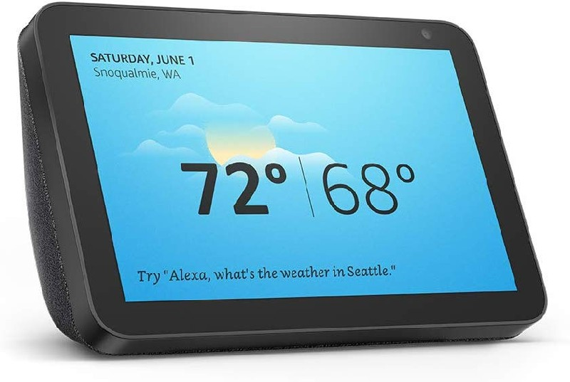 Echo Show negro mostrando el clima, 72/68 grados y fecha. El fondo muestra un cielo nublado.