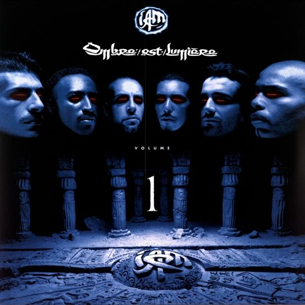 Albumcover mit sechs Gesichtern. Titel ist auf Französisch. Blaue Säulen im Hintergrund und die Zahl eins.