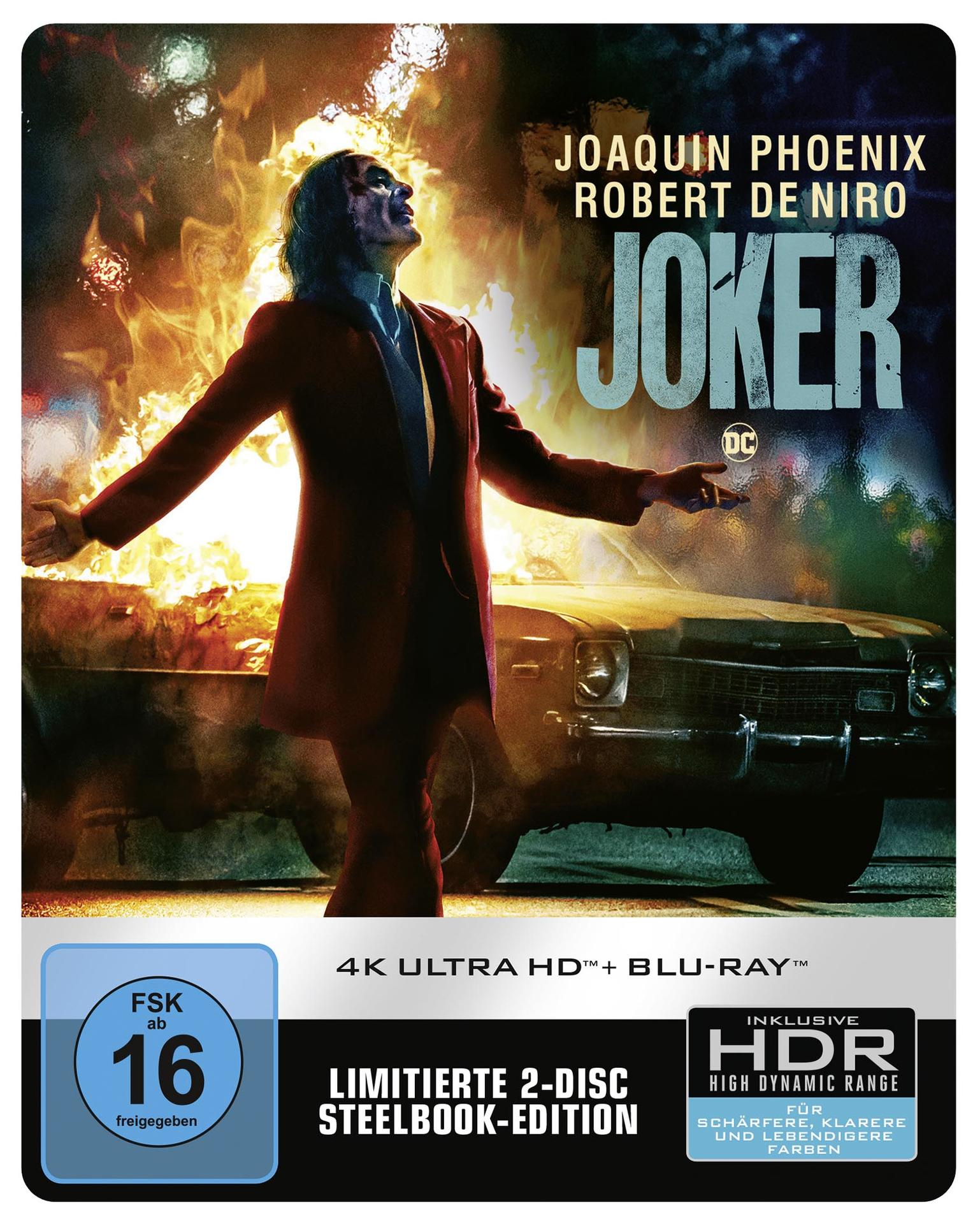 Das Joker-Filmplakat zeigt den Joker mit Feuer, Auto und Text.
