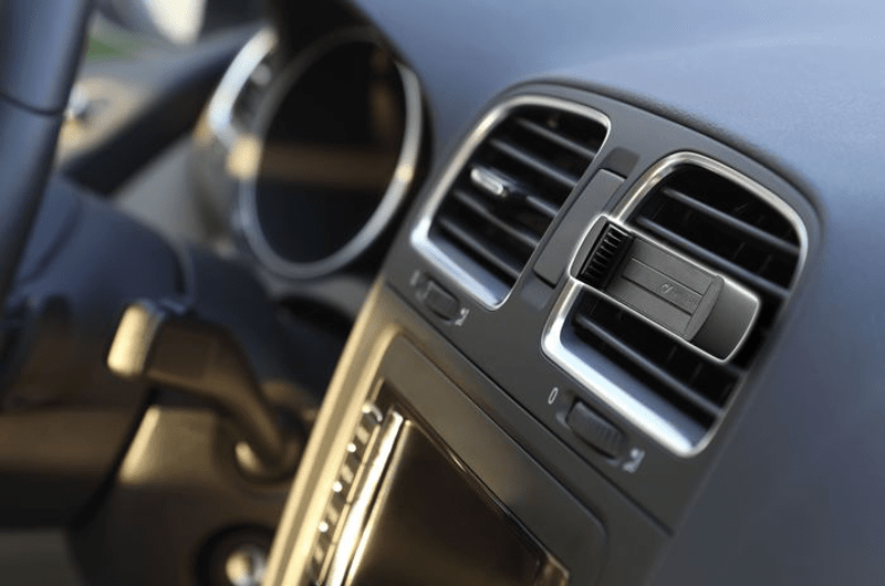 Gros plan de l'intérieur de la voiture, bouches d'aération visibles.