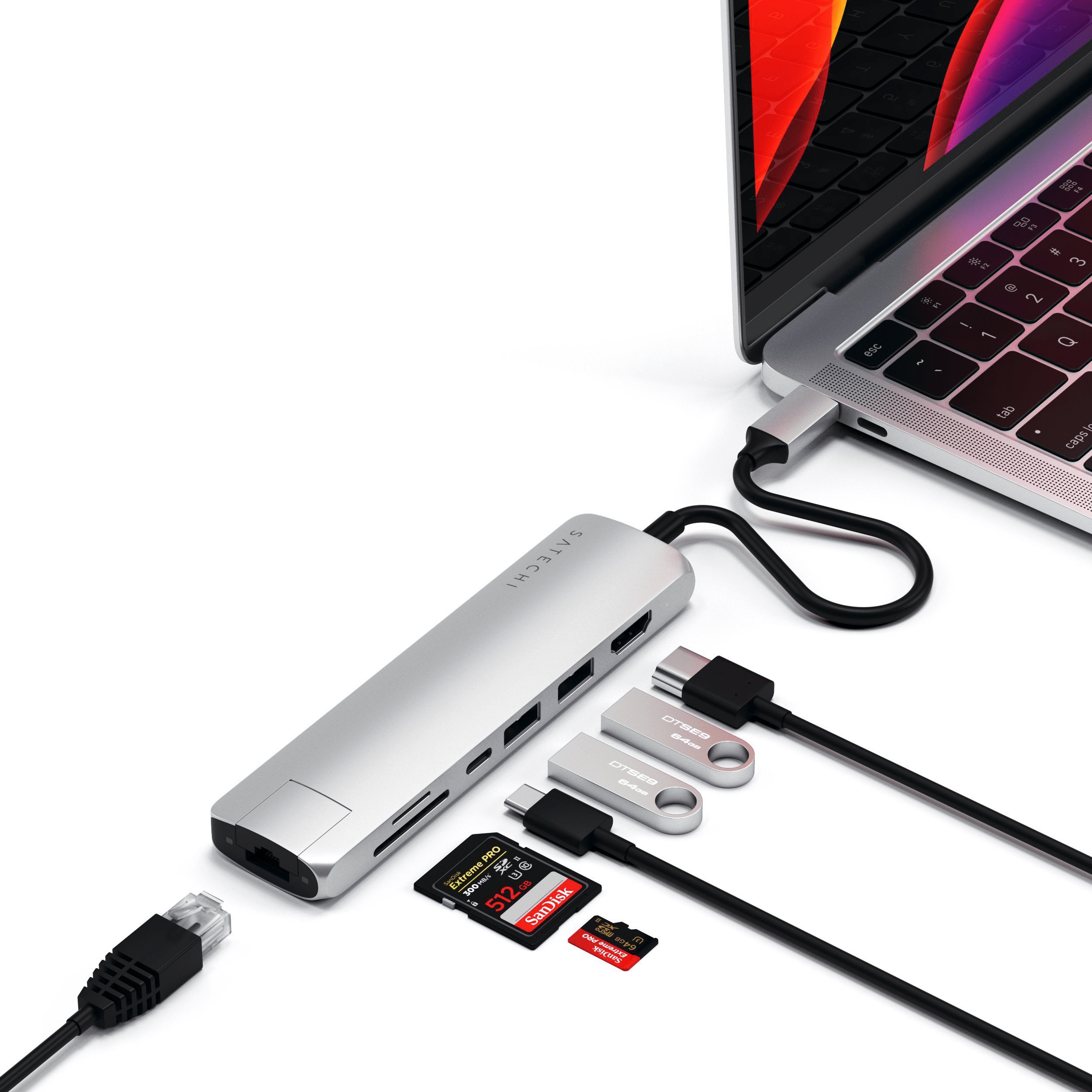Laptop, verbunden mit einem silbernen Satechi-Hub, an dem mehrere Geräte angeschlossen sind.