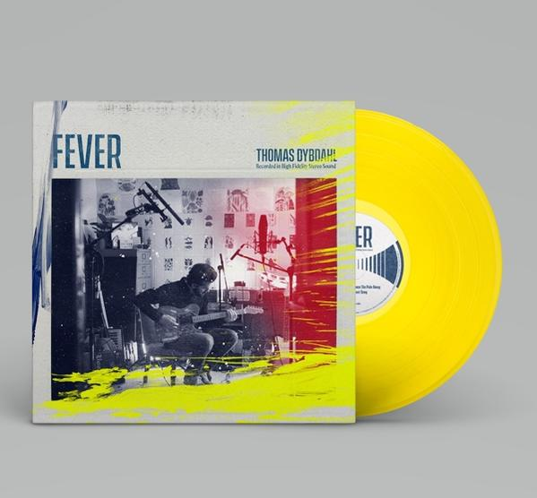Un disque vinyle jaune avec la pochette d'un homme jouant de la guitare en studio.