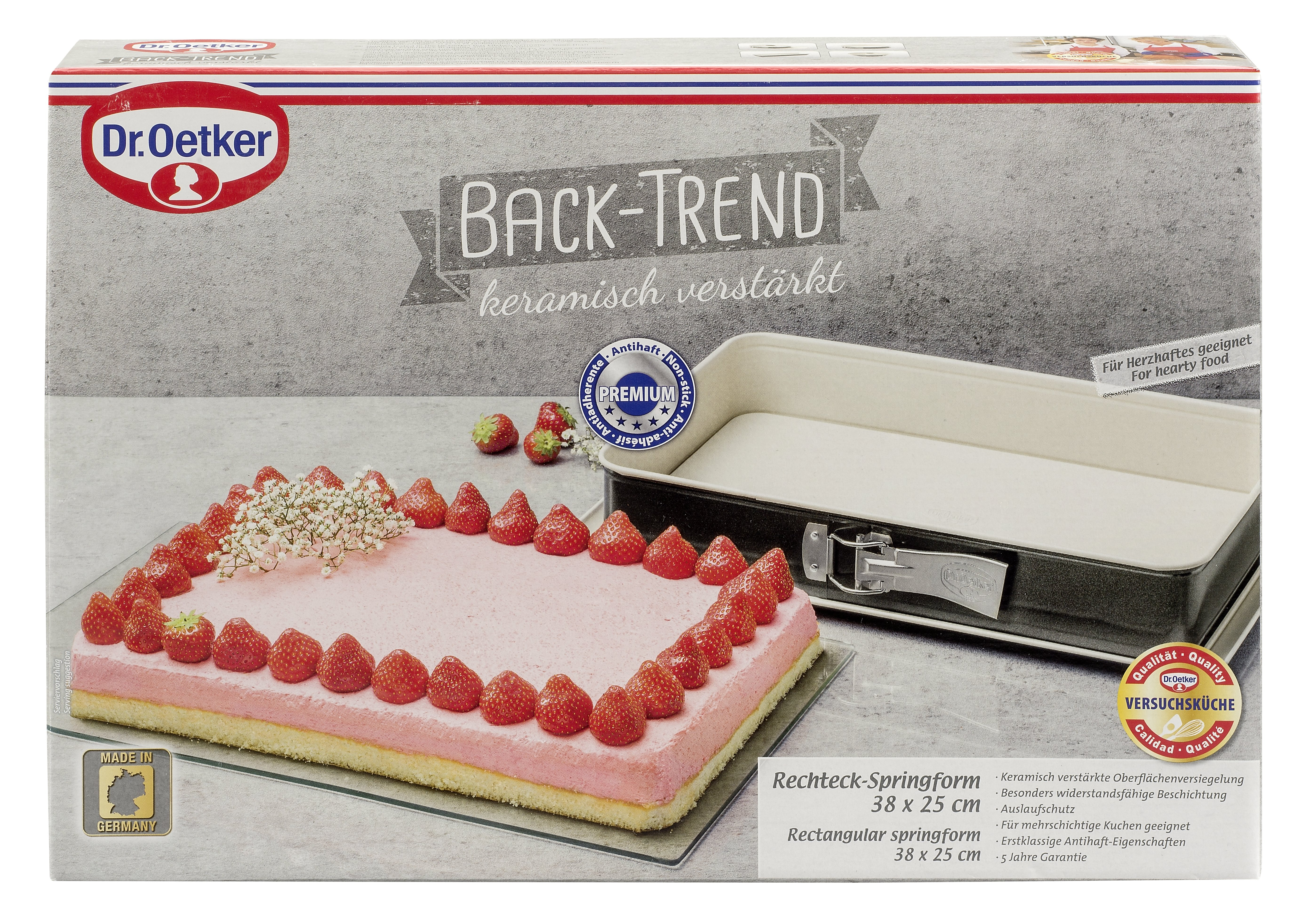 Rechteckige Backform mit einem rosa Kuchen, der mit Erdbeeren verziert ist. Weiße Box mit Text.