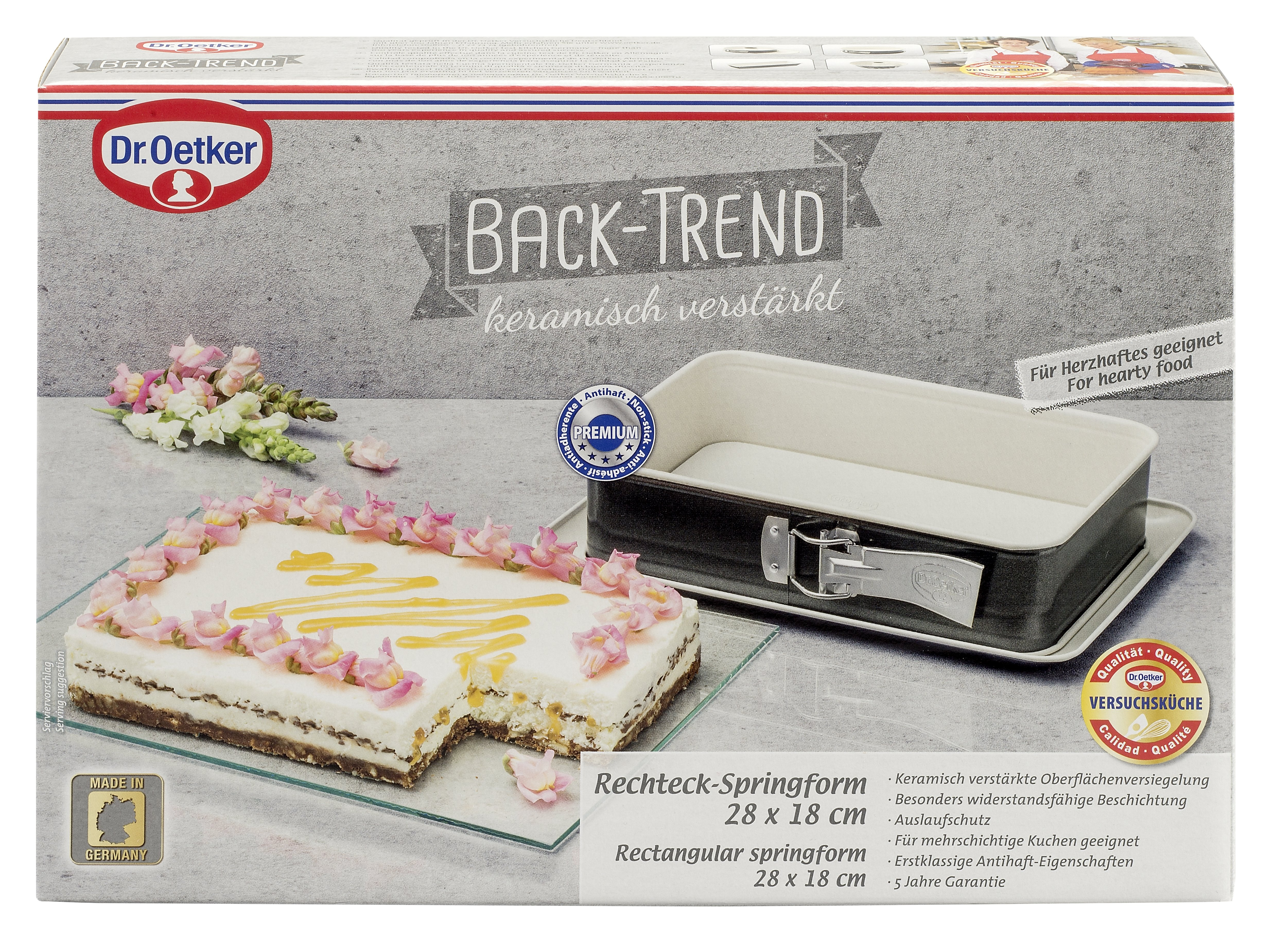 Ein Kuchen in einer rechteckigen Springform mit einer Schachtel und Text.