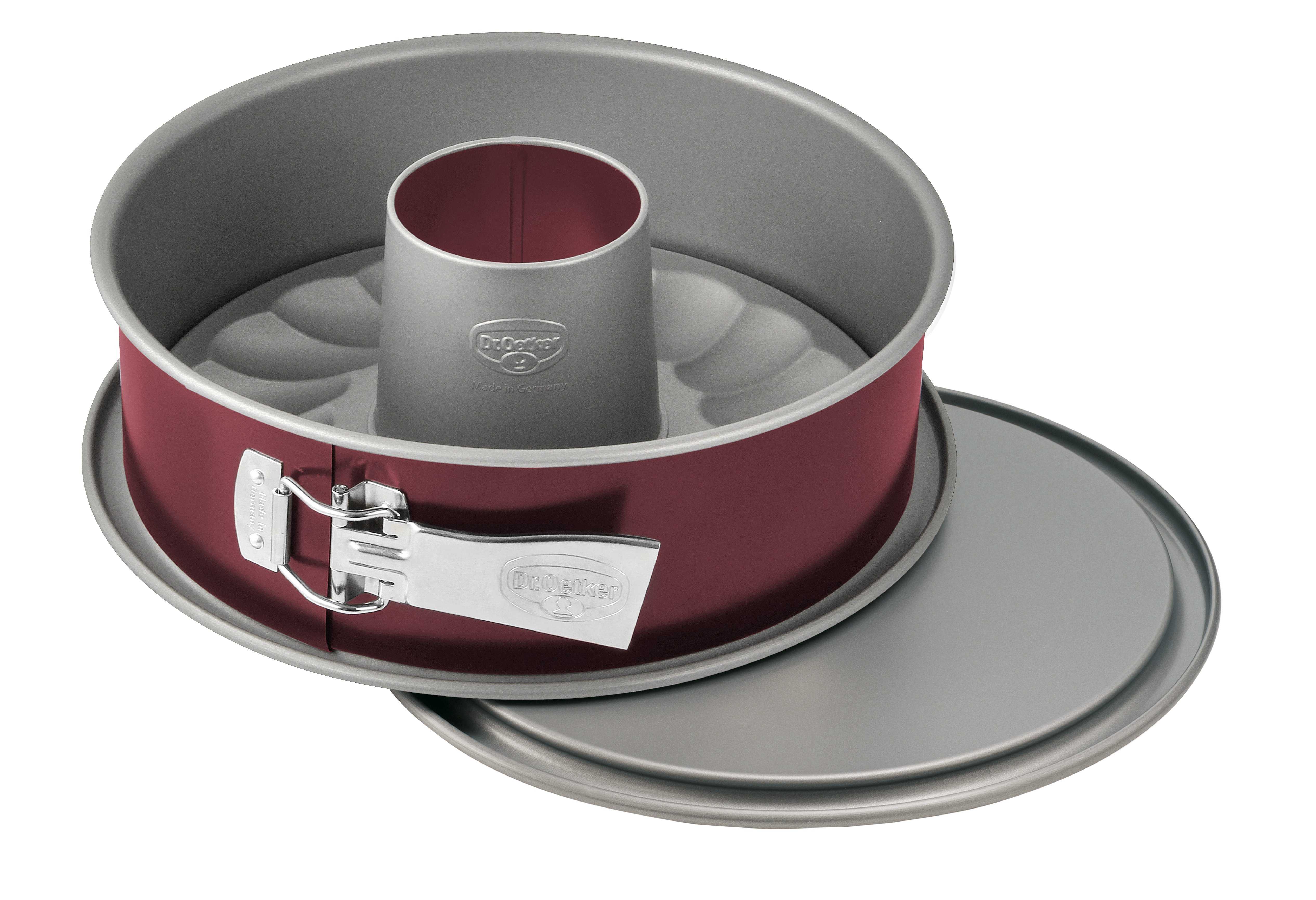 Runde rote Springform mit silberfarbenem Boden, Griff und Innenrohr. Deckel ist zur Seite.