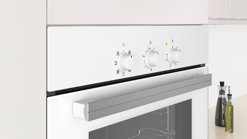 Primer plano del panel de control de un horno blanco con tres mandos y una barra.