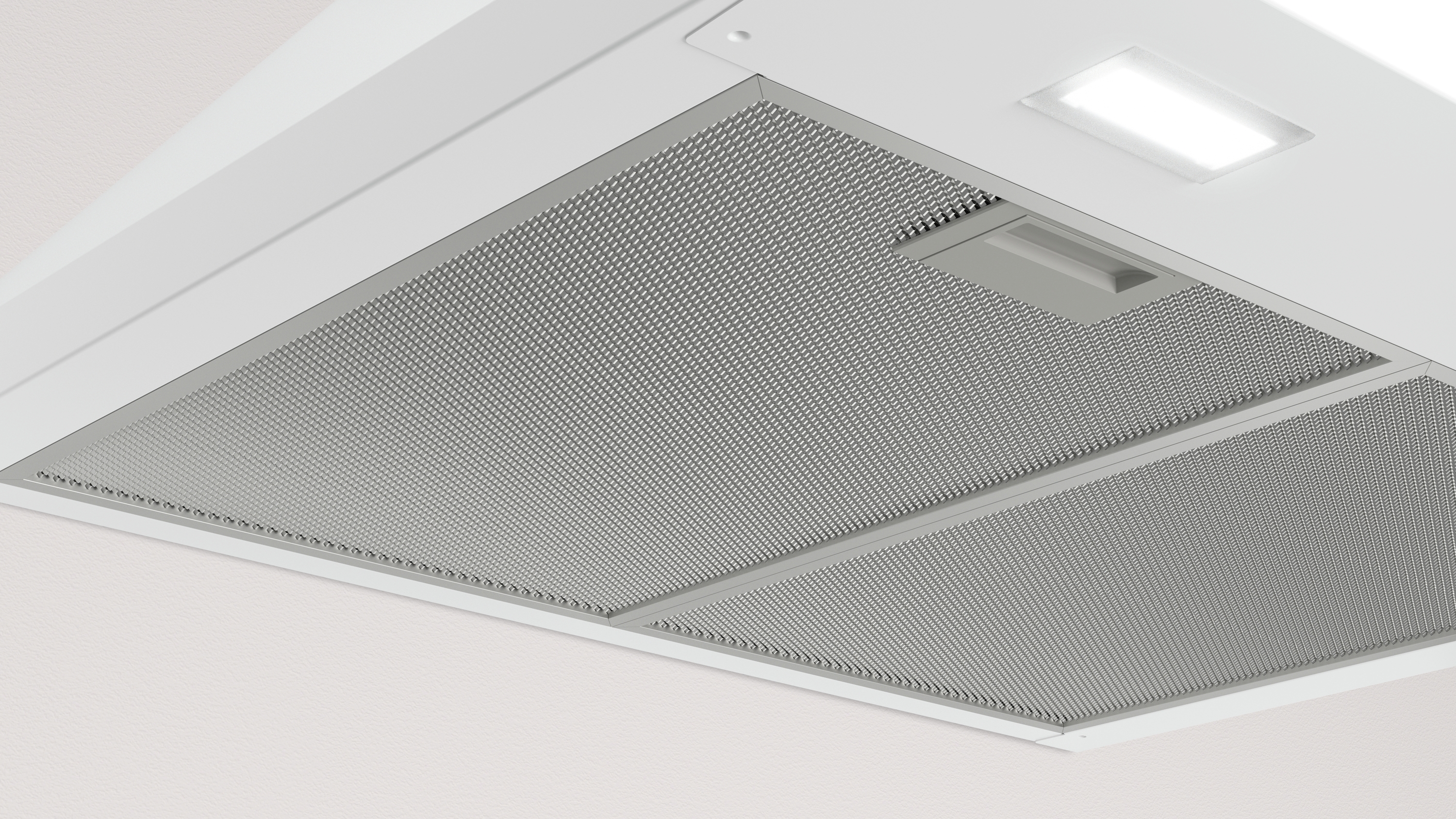 Primer plano del filtro de una campana extractora. Tiene un diseño de malla y una luz rectangular.