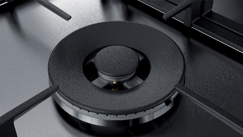 Primer plano del quemador negro de una cocina de gas, con soporte central y soportes.