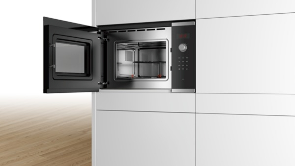 Un horno microondas, puerta abierta, con interior de acero inoxidable.