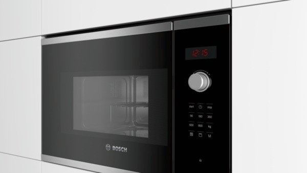 Horno microondas empotrado. Puerta negra, con reloj digital y panel de control.