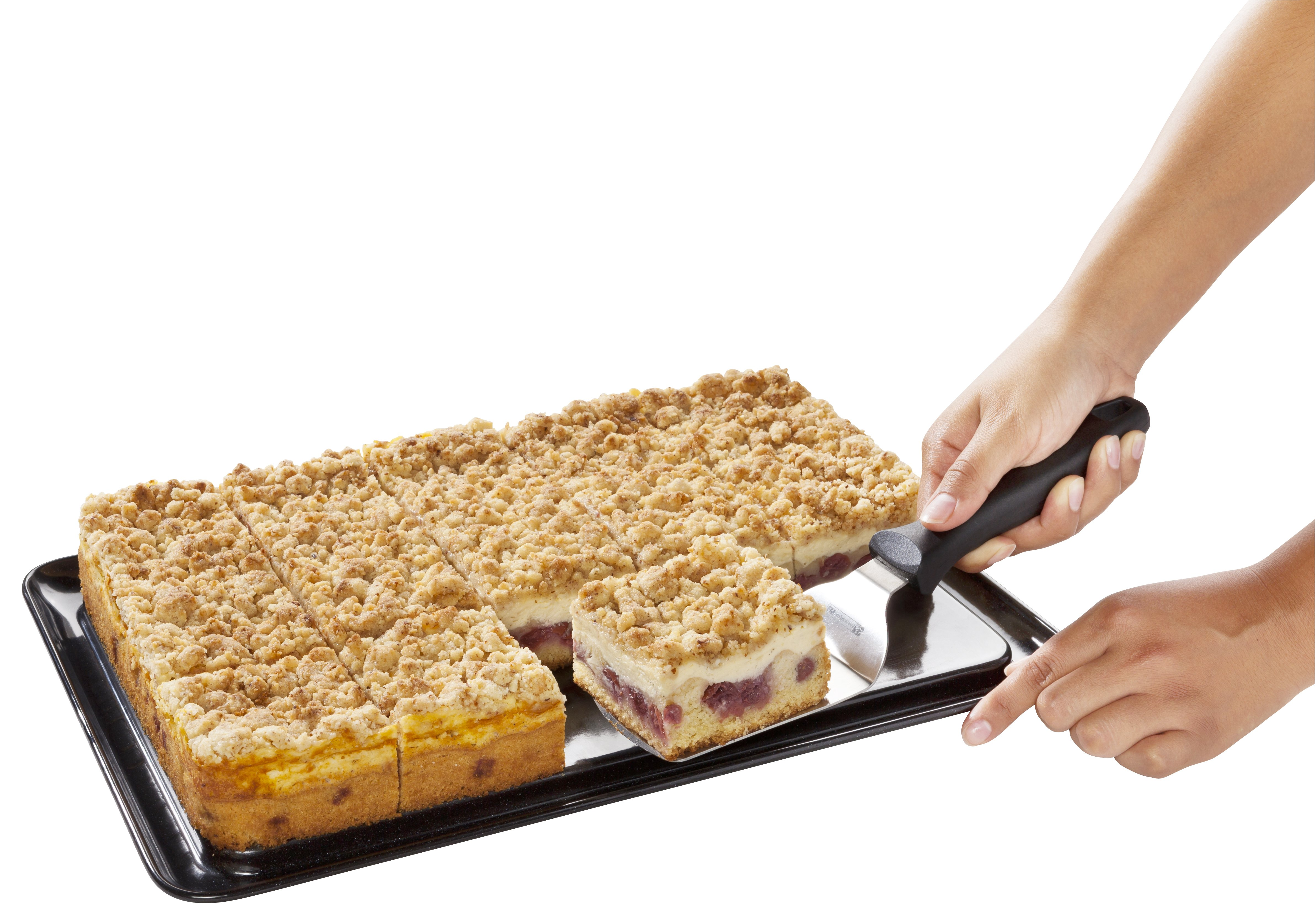 Eine Hand, die mit einem Spatel ein quadratisches Kuchenstück serviert.