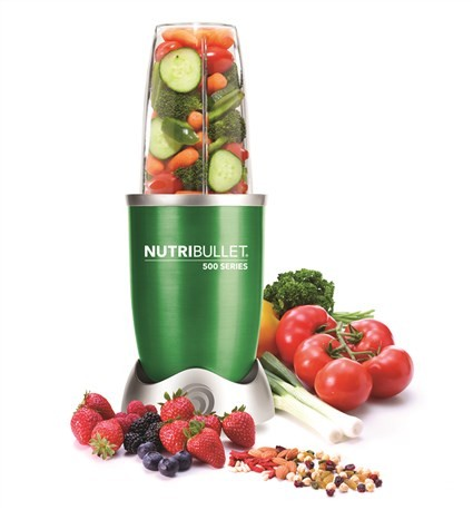 Una licuadora NutriBullet verde con verduras y frutas al lado.