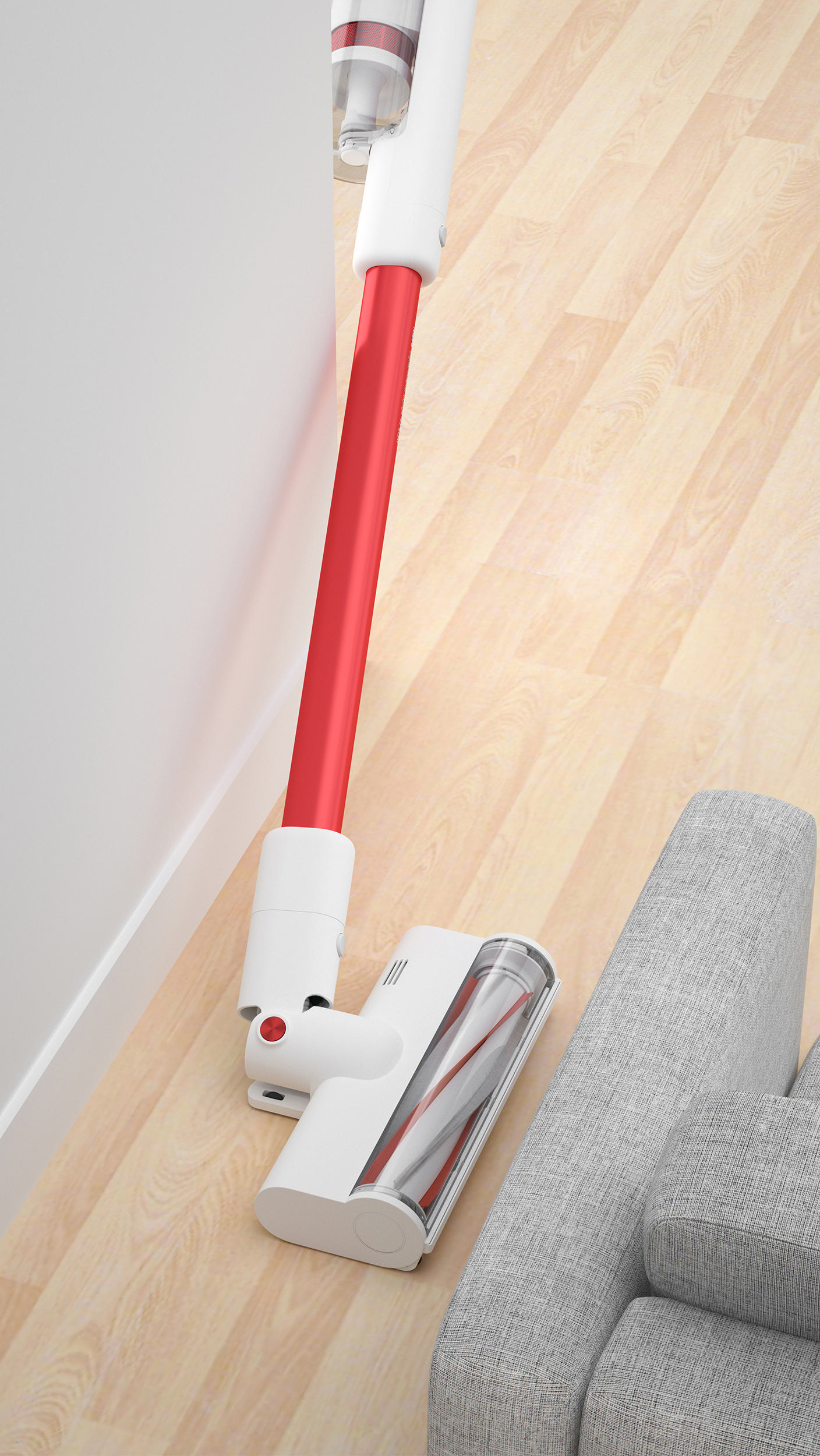 Kabelloser Staubsauger in Weiß und Rot auf Holzboden neben einer Couch.