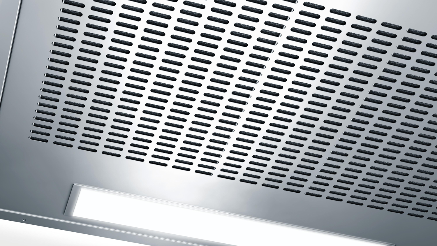A metal ceiling with perforated design and a white, horizontal light fixture.