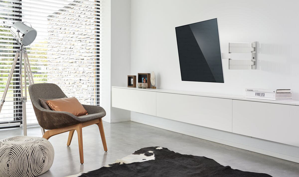 Wohnzimmer mit TV an der Wand, Stuhl, Teppich und Dekoration.