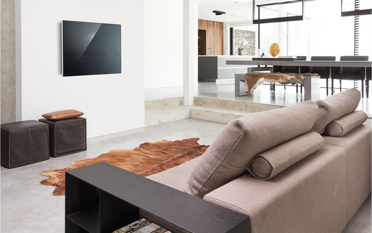Fernseher an weißer Wand in modernem Wohnzimmer mit Möbeln.