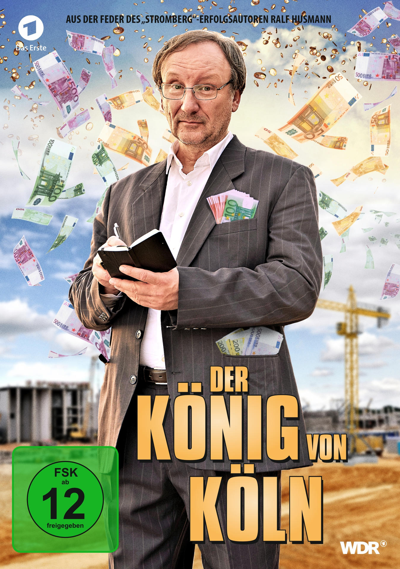 DVD-Cover mit einem Mann im Anzug mit fallendem Geld, einer Baustelle und einem grünen FSK-12-Label.