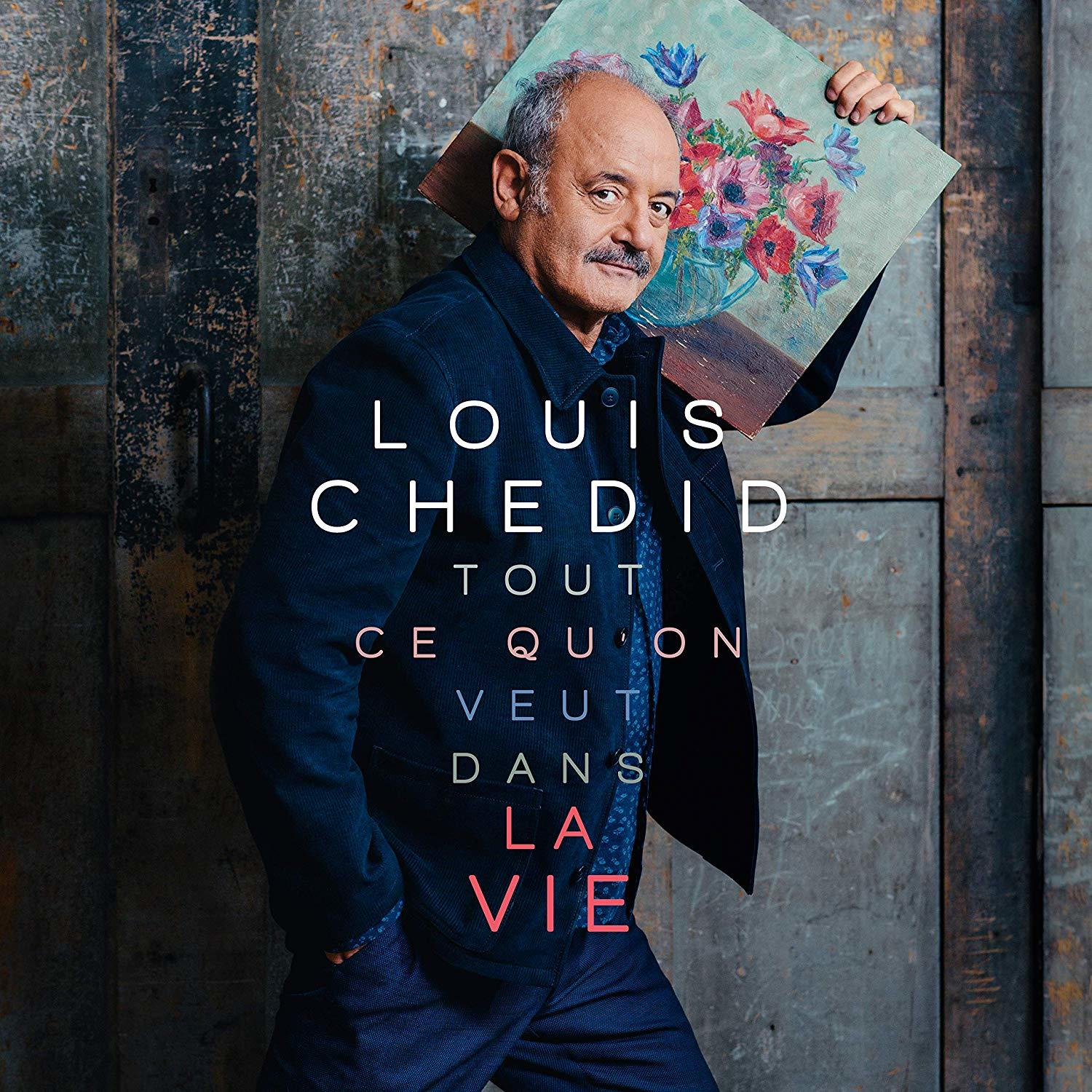 Man die een schilderij van bloemen vasthoudt. Tekst: Louis Chedid, Tout Ce Qu'on Veut Dans La Vie.