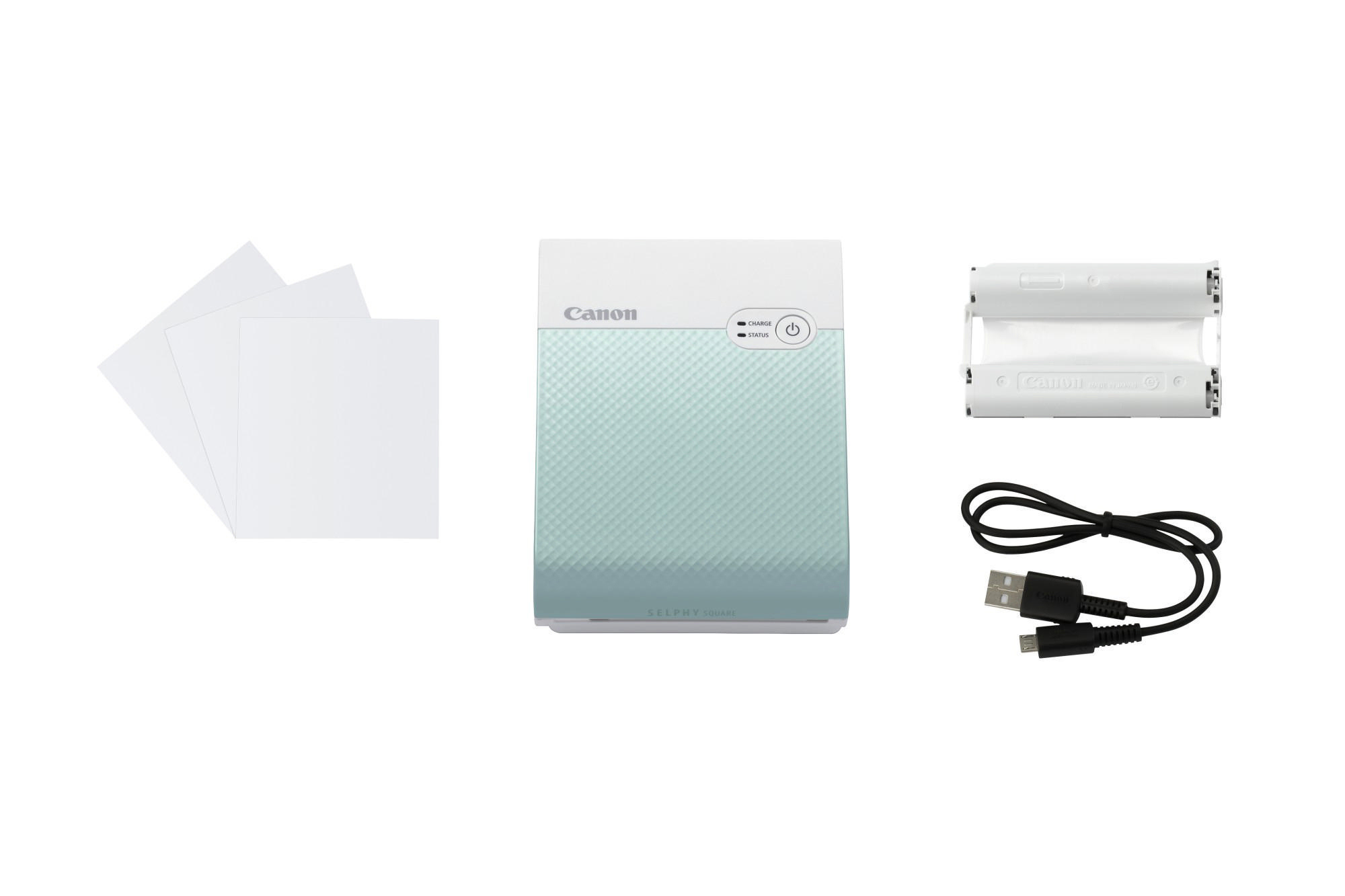 Canon Selphy Drucker mit Papier und einem Ladekabel.