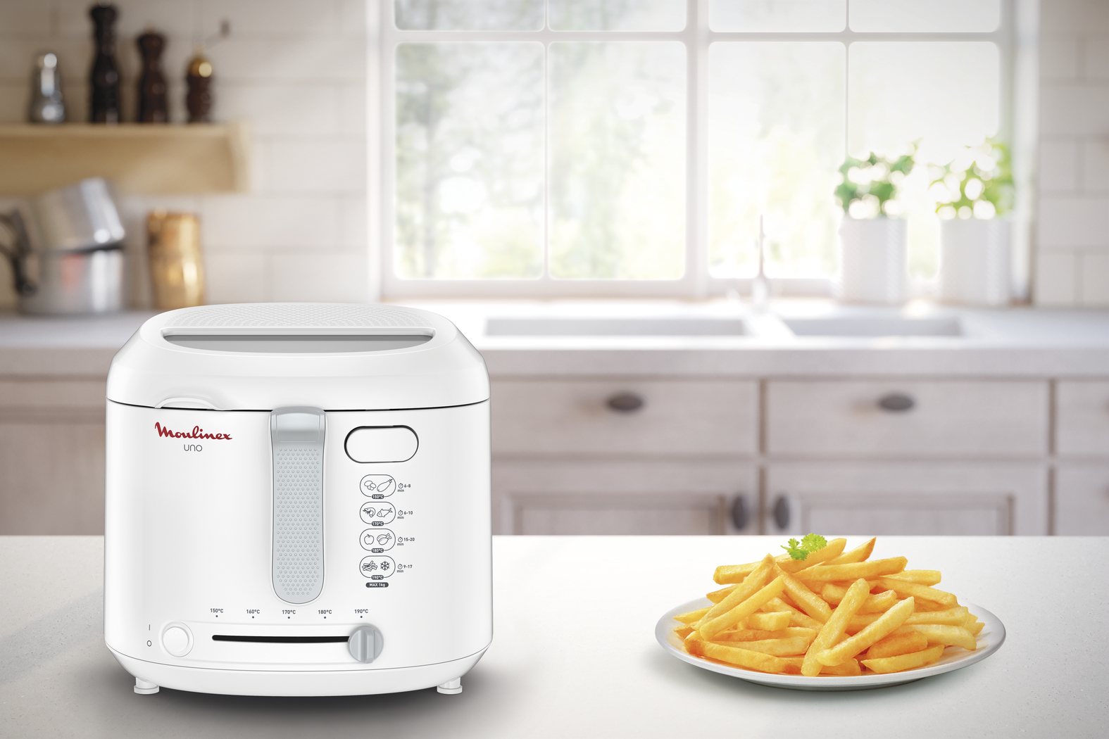 Une friteuse blanche avec des frites dans une assiette, sur une table, dans une cuisine.