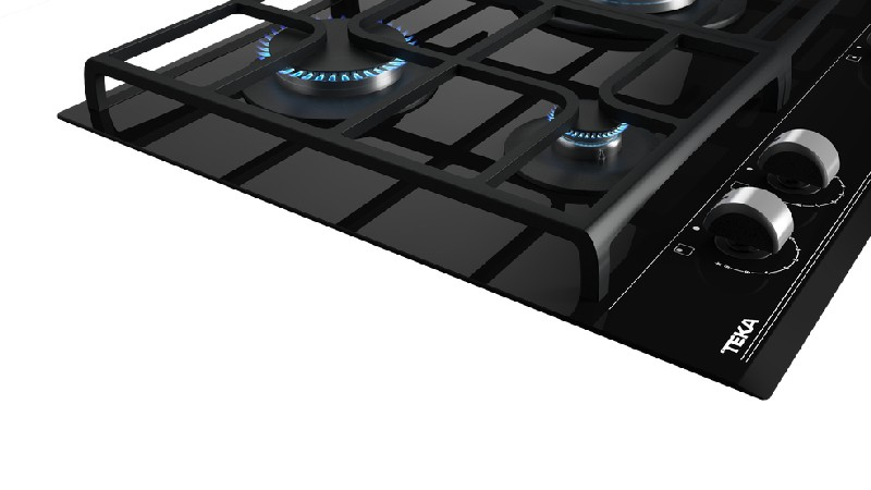 Primer plano de una placa de gas negra con tres quemadores y un marco de acero inoxidable.