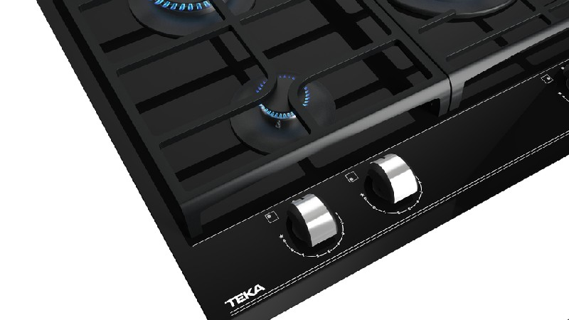 Placa de cocina negra con cuatro quemadores, mandos plateados y logo TEKA.