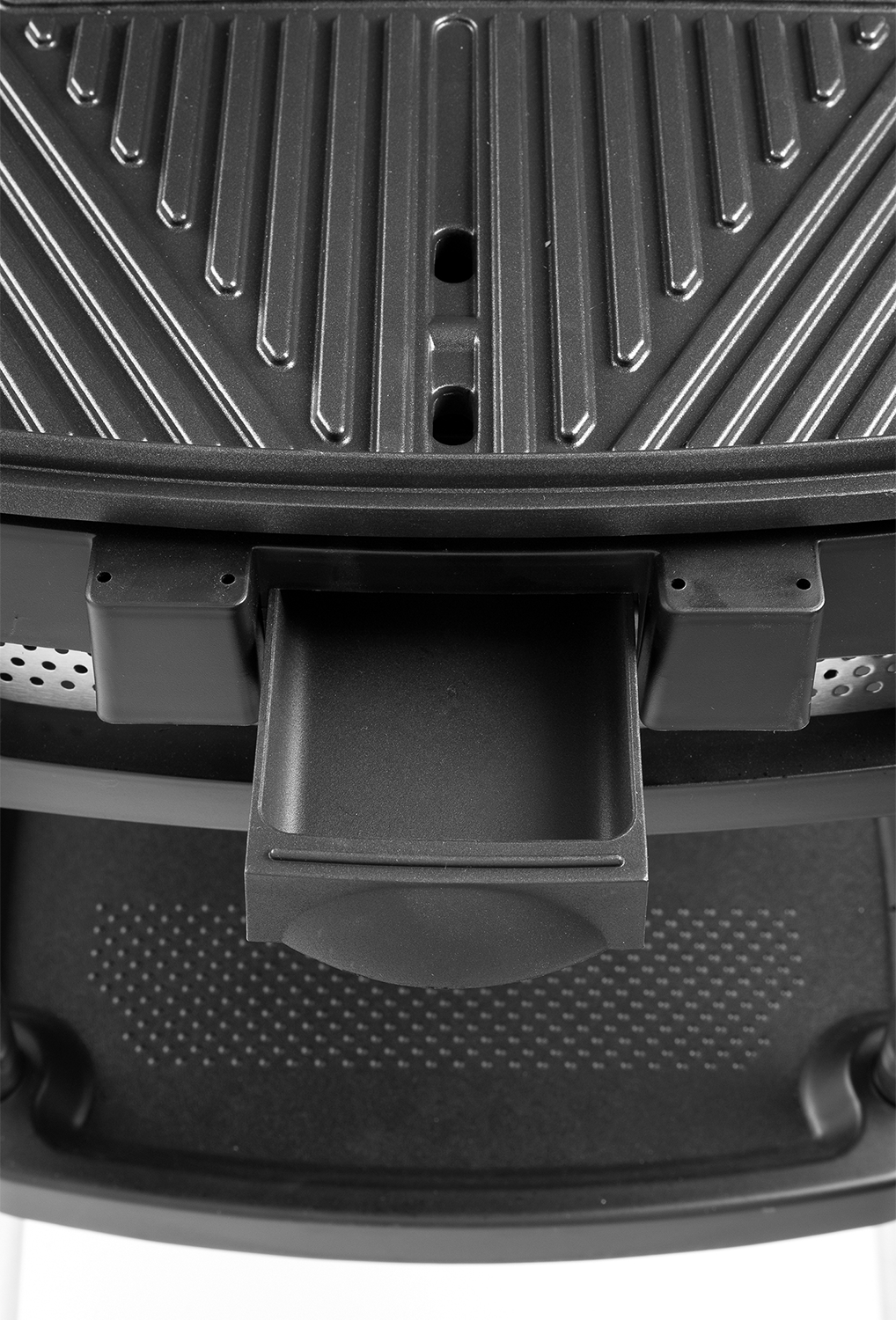 Close-up van een zwarte grill met een vetopvangbak.