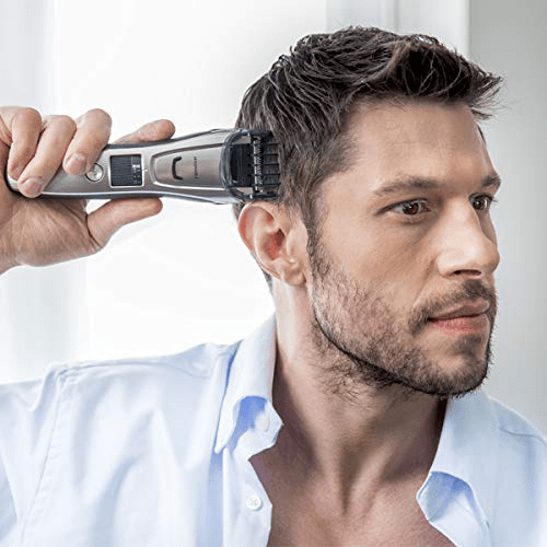 Mann, der sich mit einem silbernen und schwarzen Haarschneider die Haare schneidet.
