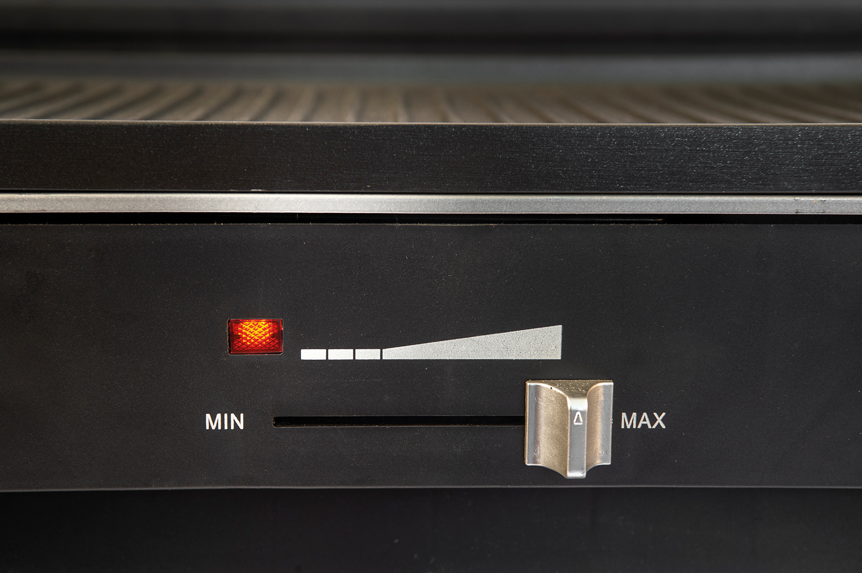Close-up of a black grill control panel. It has a dial labeled 'MIN' and 'MAX'.