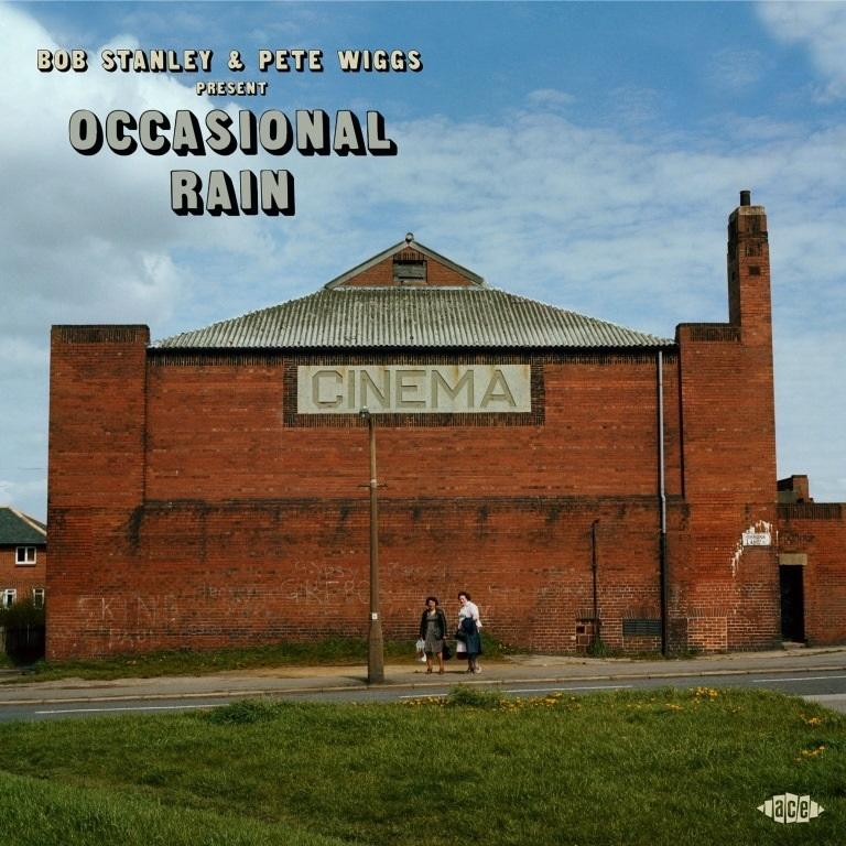 Albumhoes voor 'Occasional Rain'. Een bakstenen bioscoop, twee mensen ervoor, met een blauwe lucht.