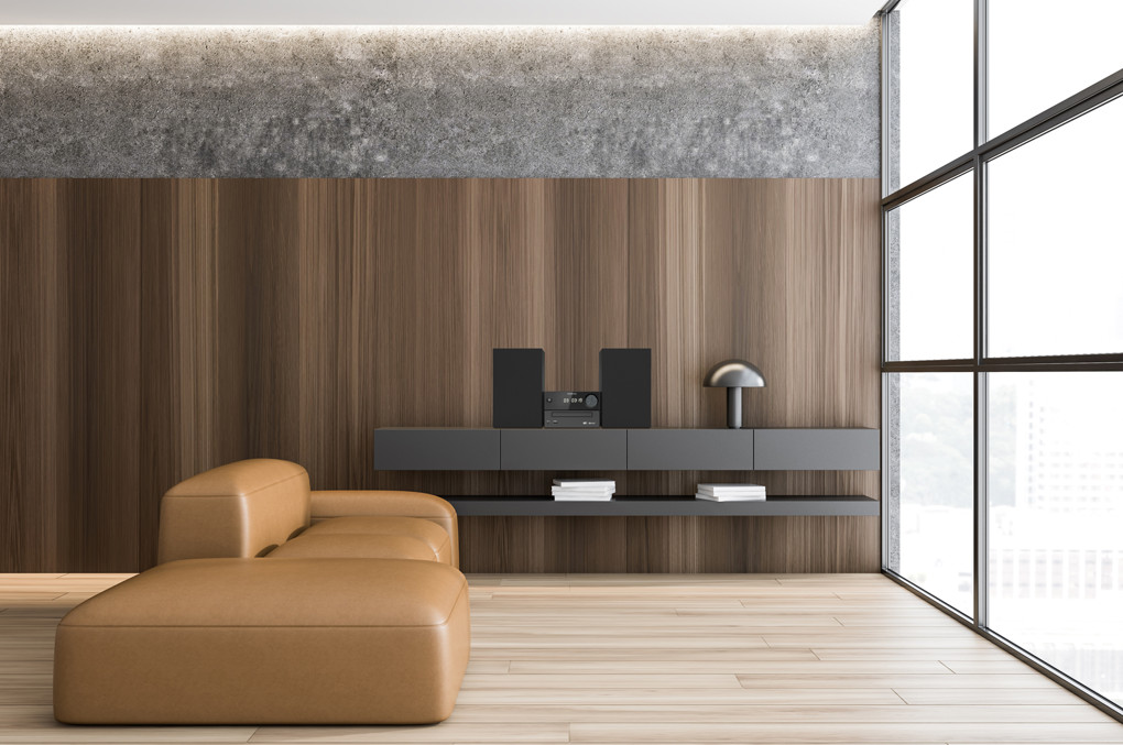 Un salon moderne avec un canapé en cuir marron, un mur en bois et une grande fenêtre.