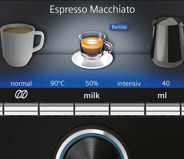 Espresso Macchiato-Getränk auf schwarzer Oberfläche. Tassen und Milchbehälter sind sichtbar.