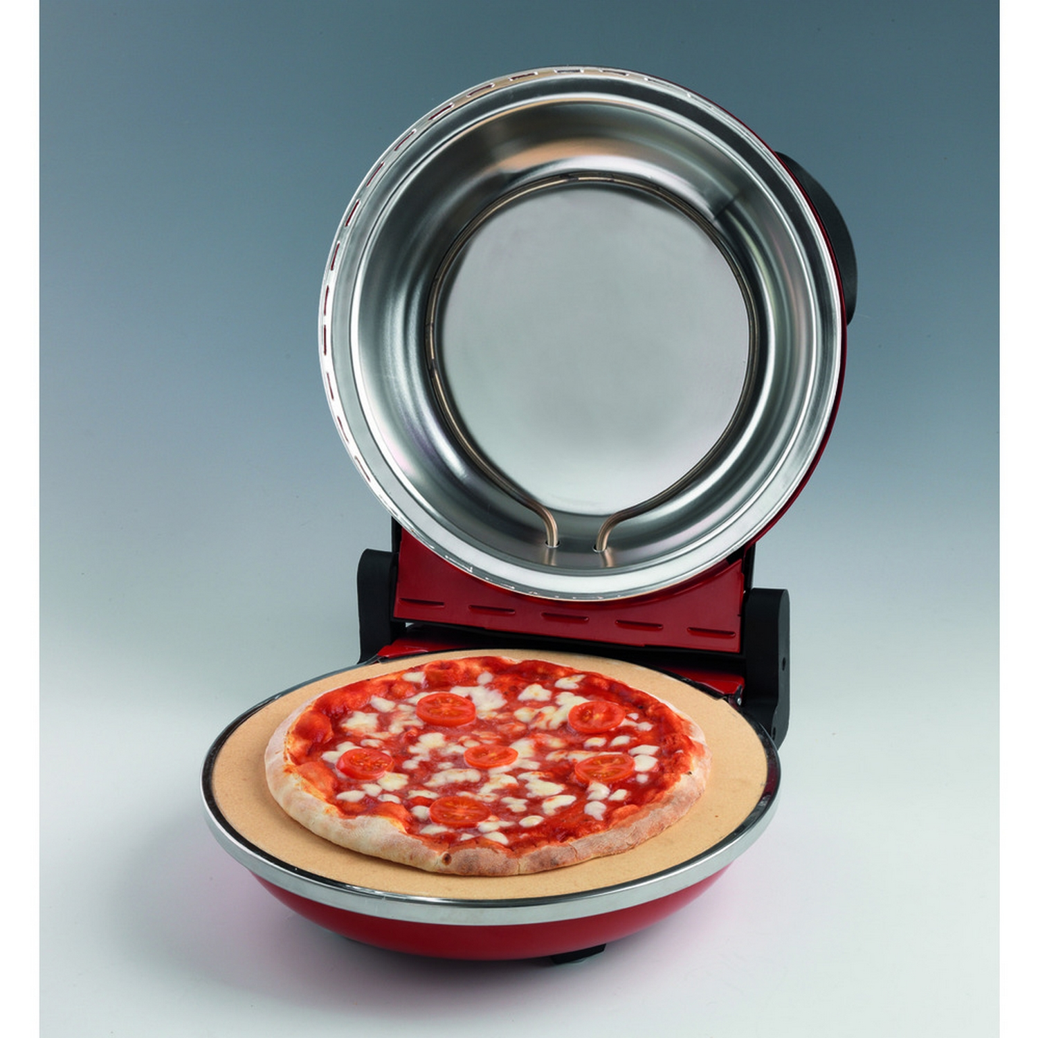 Pizza en un horno de pizza rojo, sobre una base de piedra, con queso y tomates. Horno abierto.