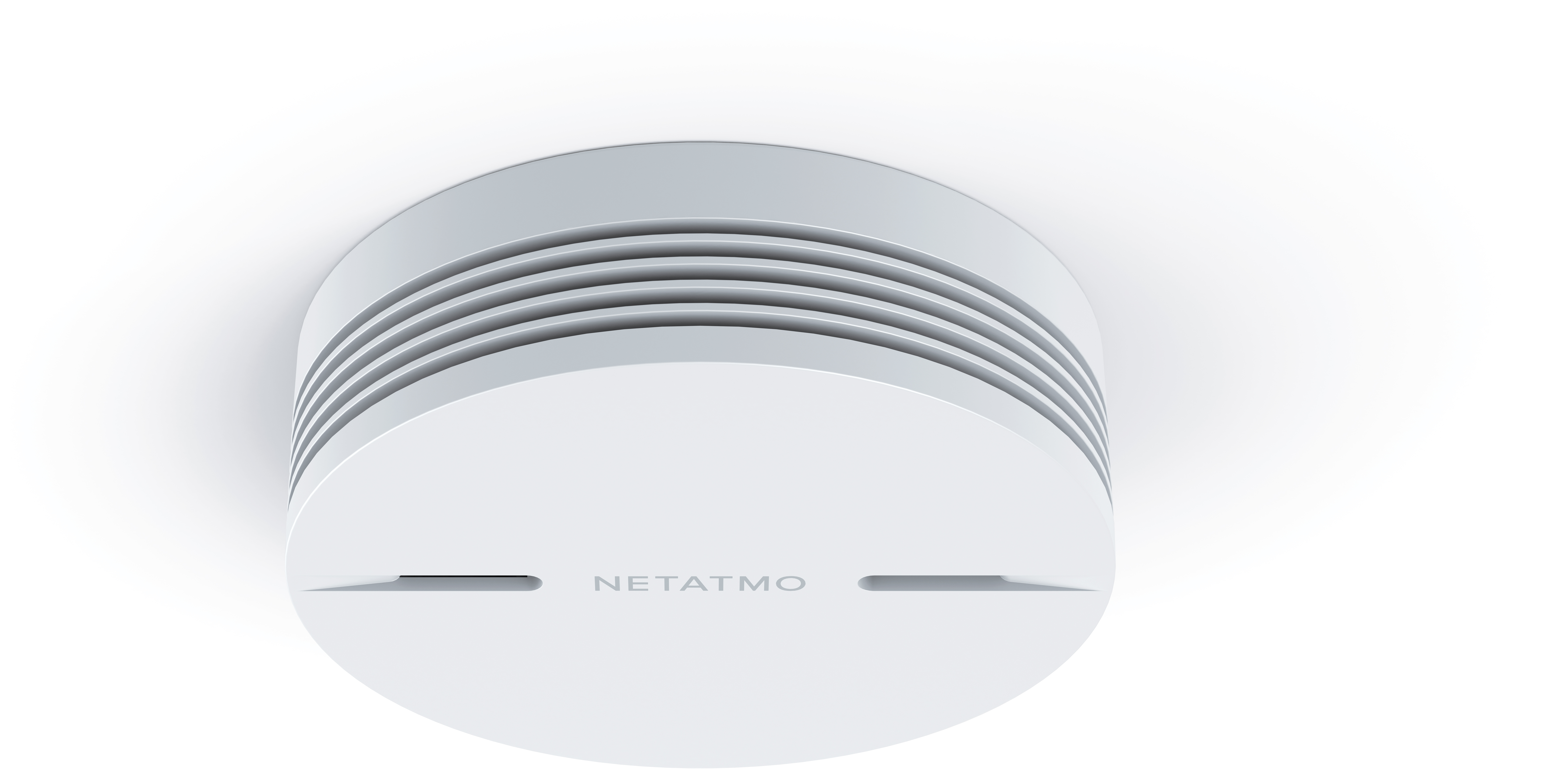 Rilevatore di fumo Netatmo bianco, forma circolare, montato su soffitto bianco.