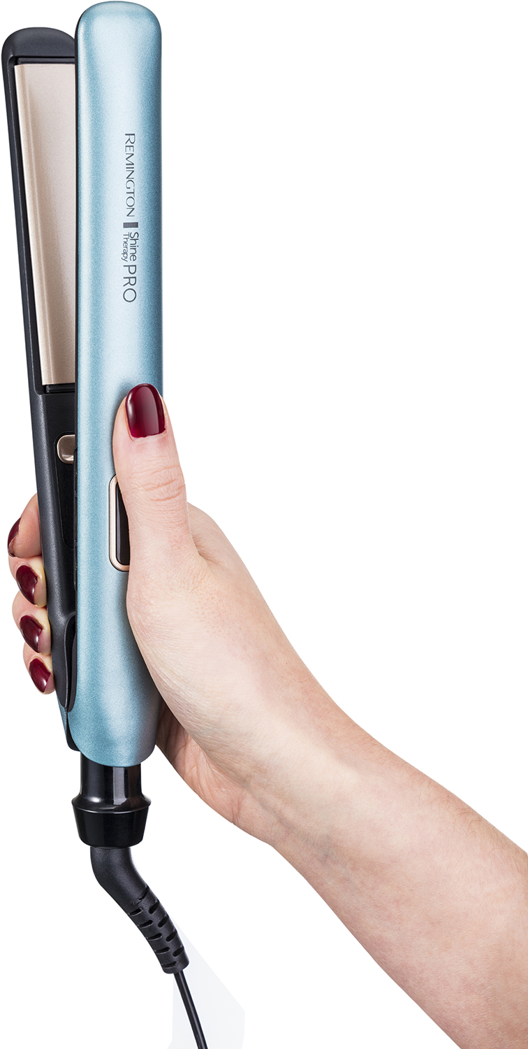 Woman's hand holding a blue hair straightener. The straightener is black and gold.