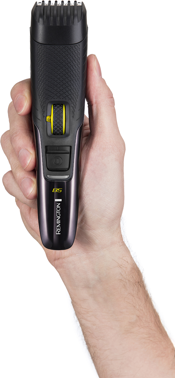 Een hand houdt een zwarte en paarse Remington B5 baardtrimmer vast.
