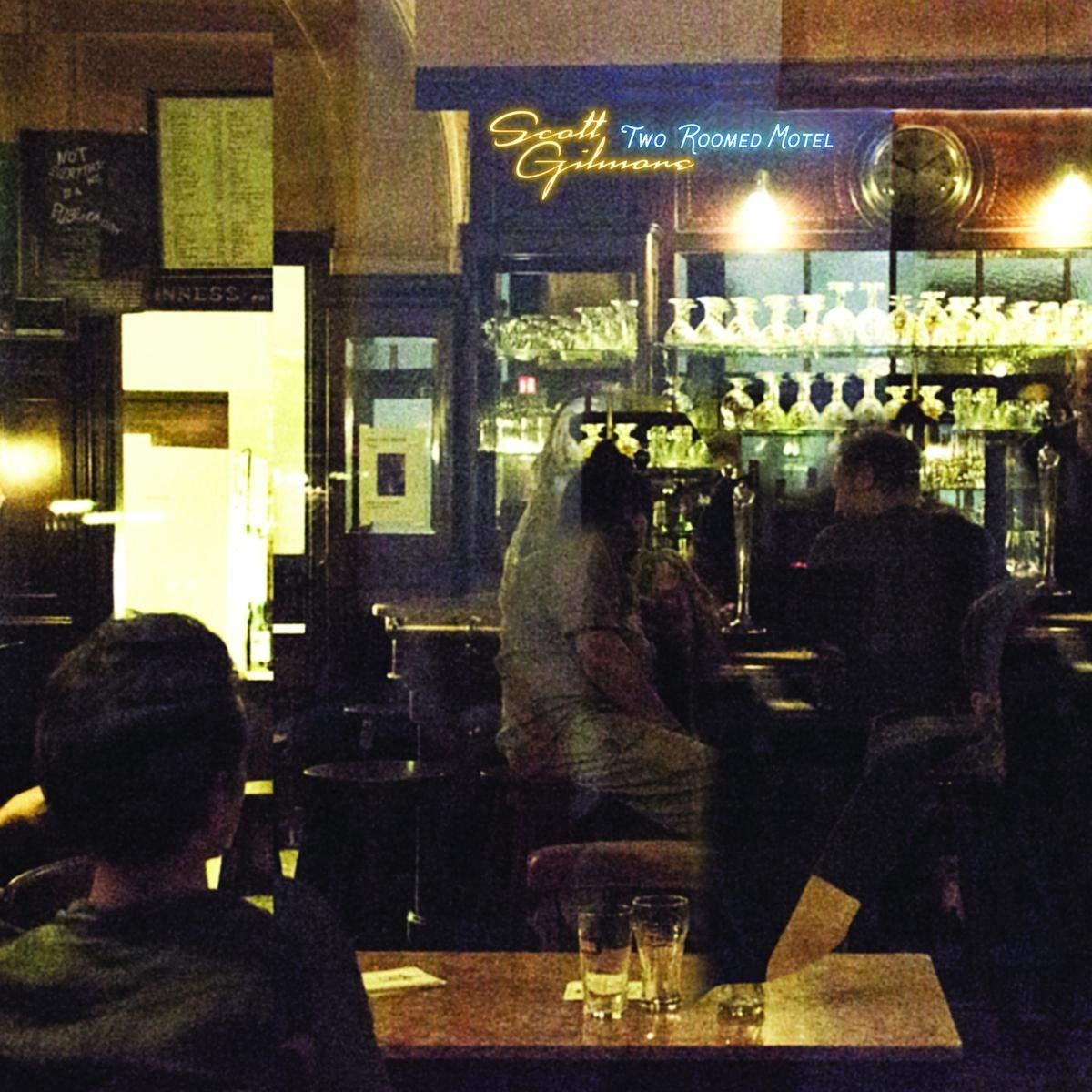 Donker interieur van een bar met gasten, tafels en een neonreclame met 'Scott Gilmore'.