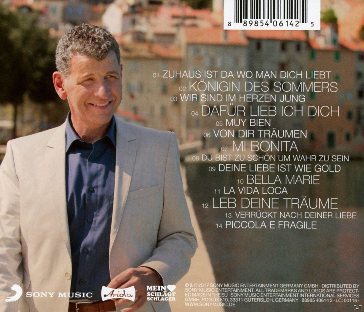 Mann im beigefarbenen Anzug lächelt in die Kamera, Albumtitel und Titelliste im Hintergrund.