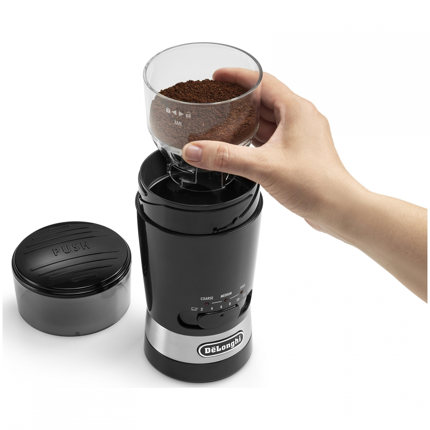 Molinillo de café negro con café molido y mano.