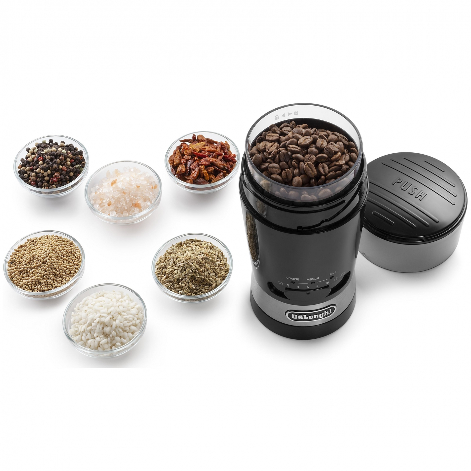 Molinillo de café con granos de café y varias especias en cuencos de vidrio sobre fondo blanco.
